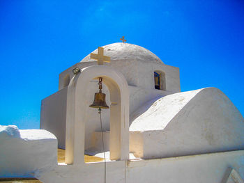 Low angle view of bell tower against blue sky