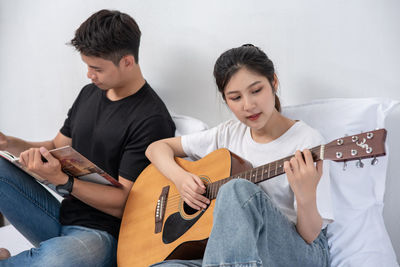 Young couple sitting on guitar