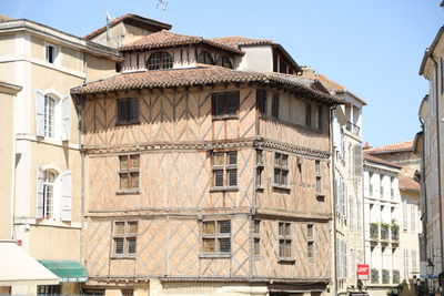 Low angle view of buildings in town against sky