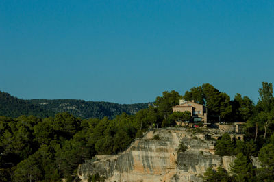 Scenic view of trees and buildings against clear blue sky