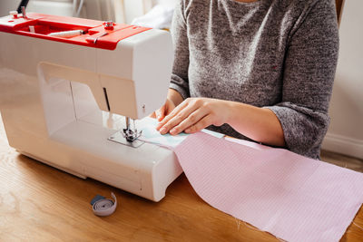 Midsection of woman working on table at home