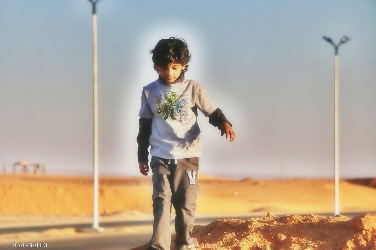 FULL LENGTH OF A YOUNG WOMAN STANDING ON GROUND