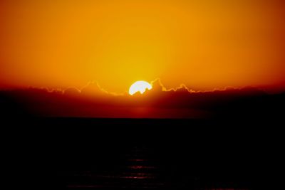 Scenic view of silhouette landscape against orange sky