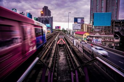 Railroad tracks in city against sky