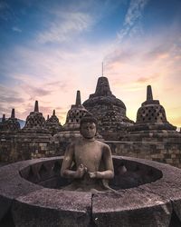 Statue of temple in building against sky