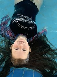 High angle portrait of woman relaxing in swimming pool