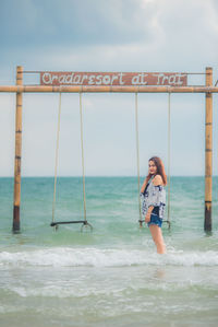 Woman standing on beach against sky