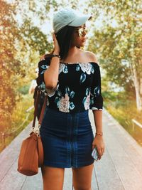 Full length of woman standing against tree