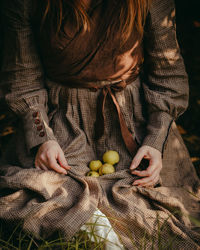 Midsection of woman holding apples