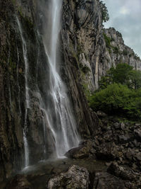 Low angle view of waterfall amidst rocks