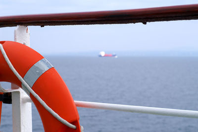 Close-up of railing over sea against sky