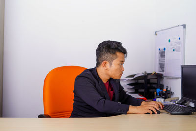 Man using mobile phone while sitting on table