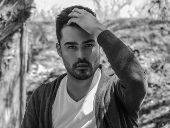 Portrait of young man against tree