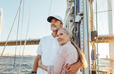 Senior couple on boat at sea against sky