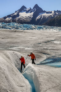 People climbing on snow covered mountain