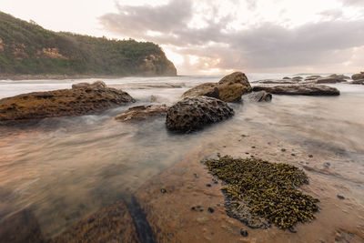 Rocks on beach against sky