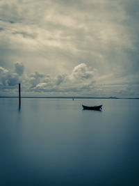 Silhouette boat in sea against sky