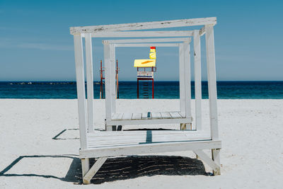 Lifeguard hut at beach against sky