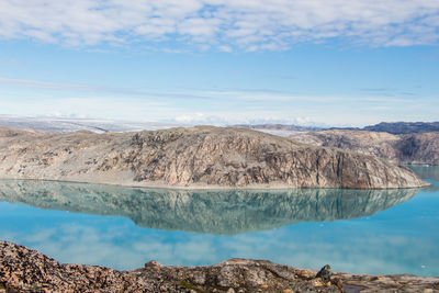 Scenic view of lake and mountains against blue sky