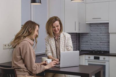 Young woman using laptop while sitting at home