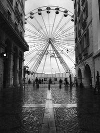 View of ferris wheel in city buildings