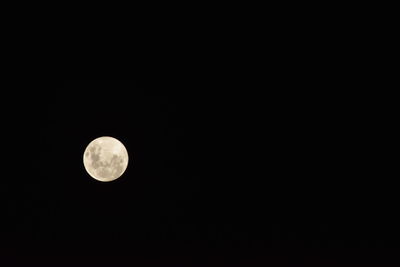 Low angle view of full moon against clear sky at night