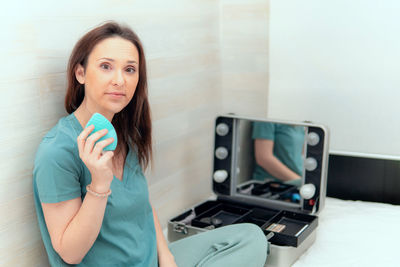 Portrait of young woman holding camera