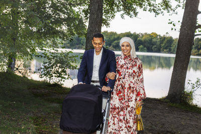 Couple with pram walking at lake