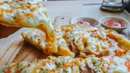 Eat the delicious pizza with meet vegetable cheese topping and sauces in restaurant