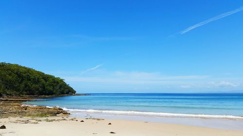 Scenic view of beach against blue sky