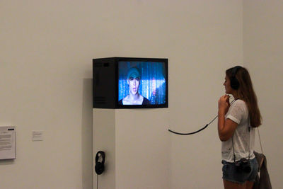 Young woman standing in front of wall