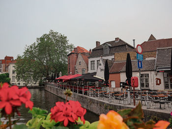 Buildings by river against sky