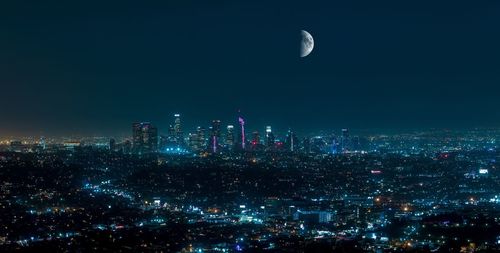 Illuminated cityscape against sky at night