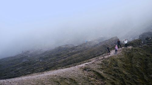 Friends on mountain during foggy weather