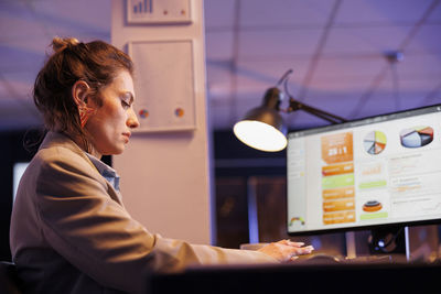 Side view of young woman using mobile phone