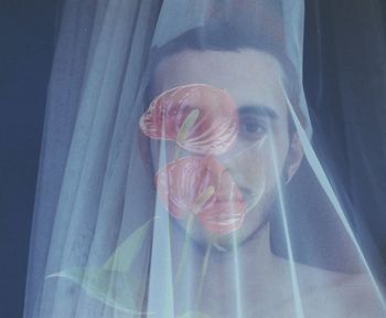 Close-up portrait of man against curtain