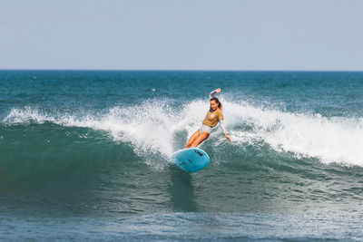 Man surfing in sea against sky