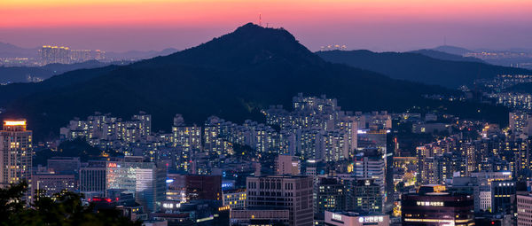 Illuminated buildings in city against sky at night