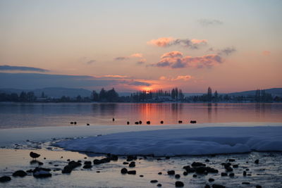 Scenic view of lake against sky during sunset