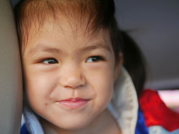 Close-up of cute girl looking away in car