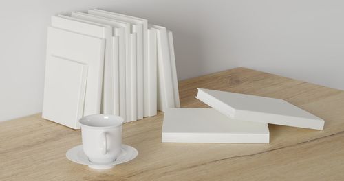 Close-up of white paper on table against wall