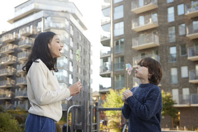 Boy and girl blowing on pinwheels outdoors