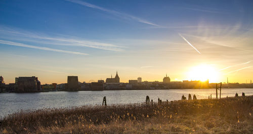 View of city at waterfront during sunset