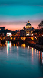 Illuminated city against sky at dusk