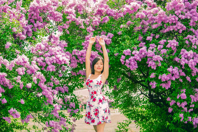 Woman standing by pink flowering plants