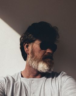 Man wearing sunglasses against wall