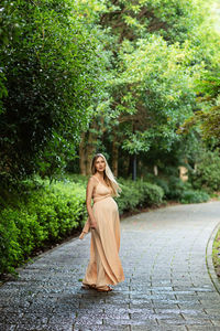 Rear view of woman standing against trees