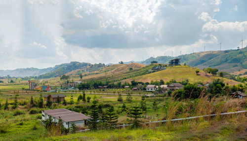 Houses near wind farm against sky