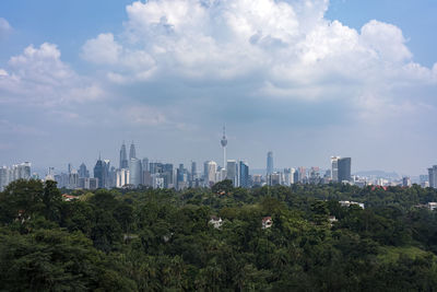 View of cityscape against cloudy sky