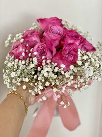 Close-up of hand holding pink rose bouquet